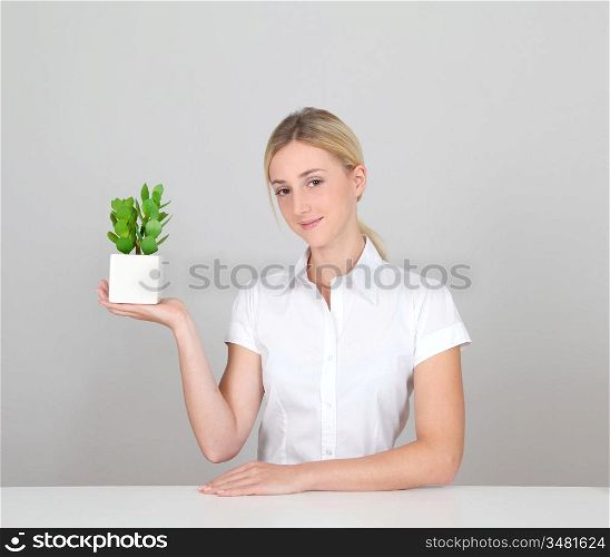 Woman holding green plant on white background