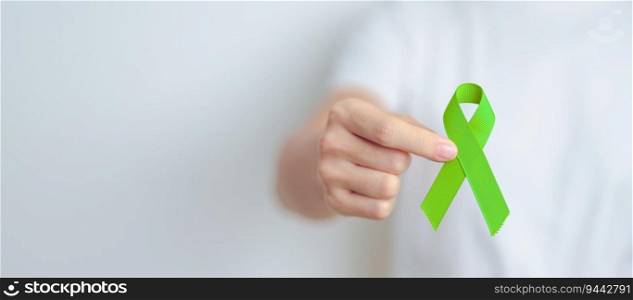 Woman holding green Ribbon for world Lymphoma Awareness September month, world Mental Health Day, Liver, Gallbladders, bile duct, cervical, kidney Cancer. Healthcare and world cancer day concept