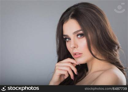 Woman holding hand on chin. Portrait of beautiful brunette woman holding hand on chin