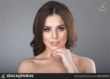 Woman holding hand on chin. Portrait of beautiful brunette woman holding hand on chin