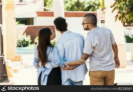 Woman holding hands with another man while walking with her boyfriend on the street. Love triangle concept. Unfaithful girl walking outdoor with her boyfriend while holding another man’s hand