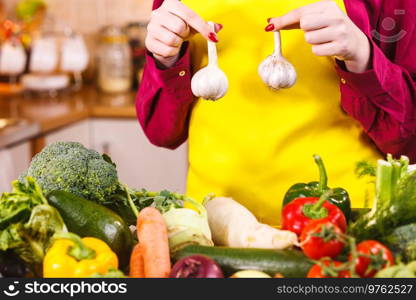 Woman holding healthy herb, two fresh natural garlic. Healthy eating and dieting concept.. Woman holding two garlic