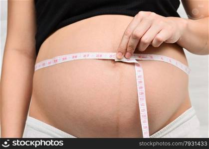 Woman holding her pregnant belly. White background.