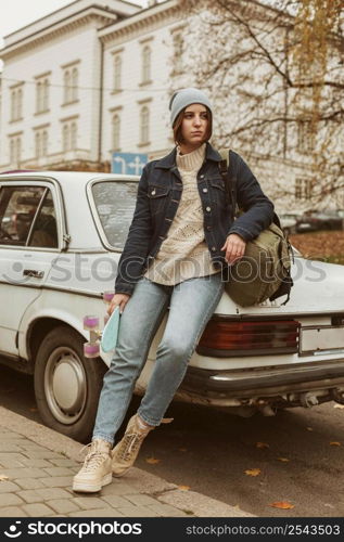 woman holding her skateboard while sitting car