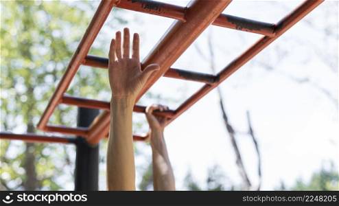 woman holding herself by metal bars