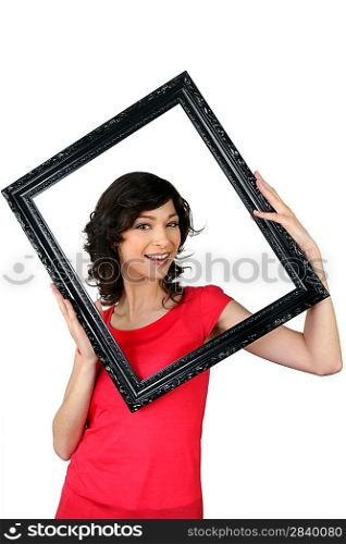 Woman holding herself within a picture frame