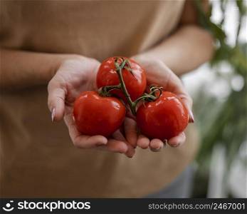 woman holding homegrown tomatoes