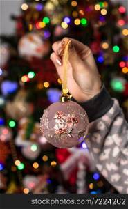Woman holding in her hands a Christmas decorative ornament