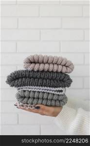 woman holding knitted caps