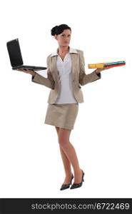 Woman holding laptop and documents
