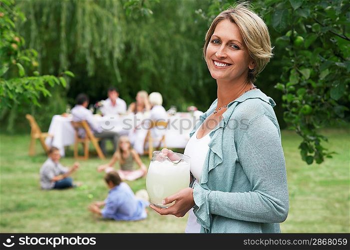 Woman Holding Lemonade at Family Picnic