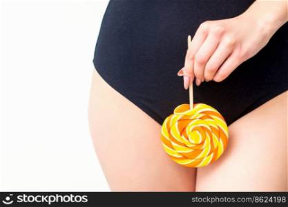 Woman holding lollipop candy on bikini zone, the concept of intimate depilation, problems of intimate hygiene. Woman holding lollipop candy on bikini zone, the concept of intimate depilation, problems of intimate hygiene.