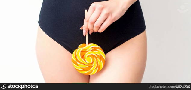 Woman holding lollipop candy on bikini zone, the concept of intimate depilation, problems of intimate hygiene. Woman holding lollipop candy on bikini zone, the concept of intimate depilation, problems of intimate hygiene.