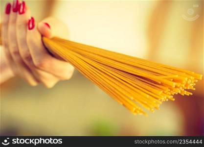 Woman holding long pasta macaroni ready to cook spaghetti. Healthy food concept.. Woman holding long pasta