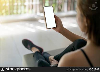 Woman holding mobile phone with blank white screen mockup.