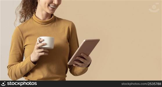 woman holding morning coffee using digital tablet