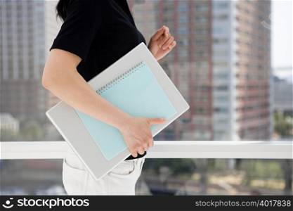 Woman holding notebook and documents