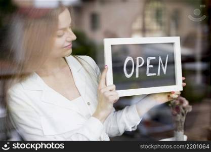woman holding open sign coffee shop window