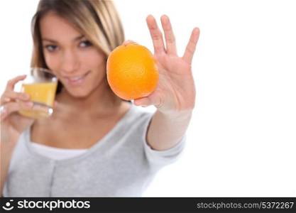 Woman holding orange and orange juice