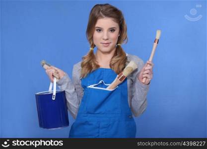 Woman holding paint brush and paint pot
