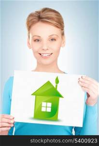woman holding paper with illustration of green eco house