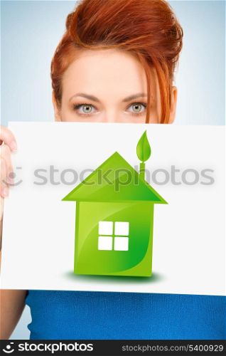 woman holding paper with illustration of green eco house