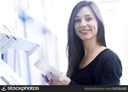 Woman holding paperwork looking at camera smiling