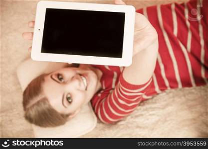 Woman holding pc tablet. Blank screen copyspace. Woman laying and holding tablet computer with blank screen showing copyspace. Happy smiling woman advertising technology.