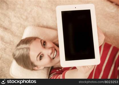 Woman holding pc tablet. Blank screen copyspace. Woman laying and holding tablet computer with blank screen showing copyspace. Happy smiling woman advertising new modern technology.