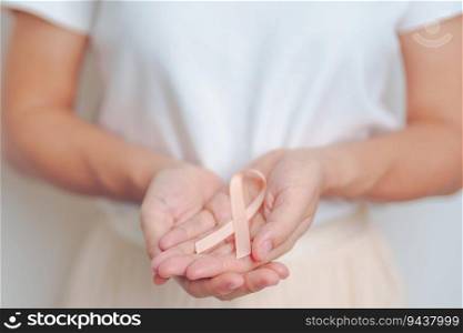 woman holding Peach Ribbon for September Uterine Cancer Awareness month. Uterus and Ovaries, Endometriosis, Hysterectomy, Uterine fibroids, Reproductive, Healthcare and World cancer day concept