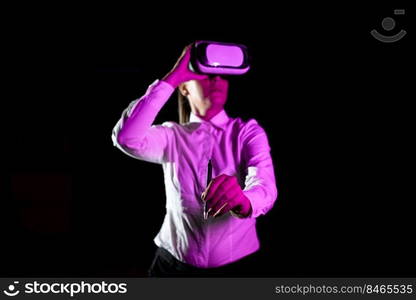 Woman Holding Pen During Professional Training Through Vr Headset.. Female Manager Wearing Virtual Reality Headset Holding Pet While Taking Professional Training. Light Falling On Woman Using Gadget And Presenting Futuristic Technology.