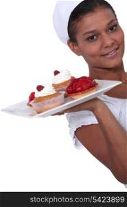 Woman holding plate of fruit tarts