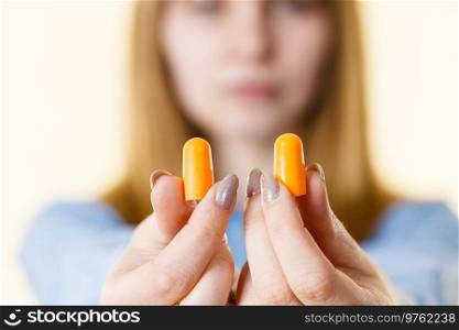 Woman holding protective ear plugs. Getting rid on noise in loud place, hearing protection concept.. Woman holding protective earplugs