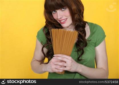 Woman holding raw spaghetti