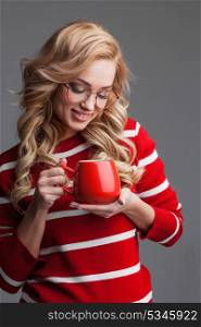 Woman holding red cup. Beautiful woman in glasses holding red cup, studio shot