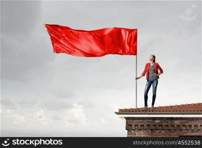 Woman holding red flag. Attractive girl in red jacket holding red waving flag
