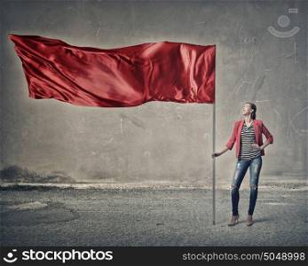 Woman holding red flag. Attractive girl in red jacket holding red waving flag