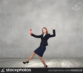 Woman holding red phone handset. Young businesswoman with red phone receiver in hands
