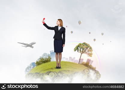 Woman holding red phone handset. Young businesswoman with red phone receiver in hands