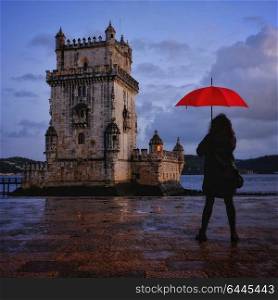 Woman holding red umbrella at Belem Tower, Lisbon Portugal