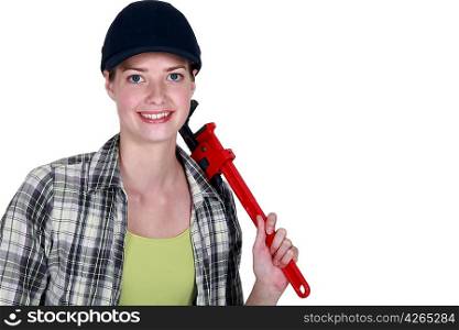 Woman holding red wrench over shoulder