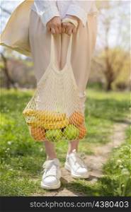 woman holding reusable bag with food nature