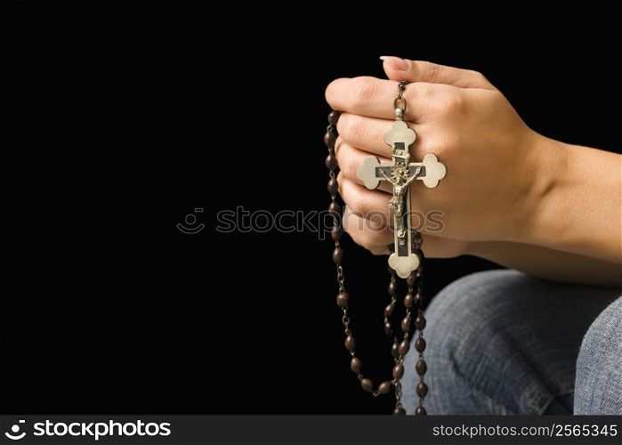Woman holding rosary with crucifix.