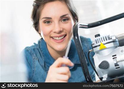 woman holding screwdriver next to portable generator