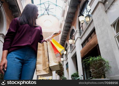 Woman holding shopping bag and using smartphone for shopping online, shopping concept.