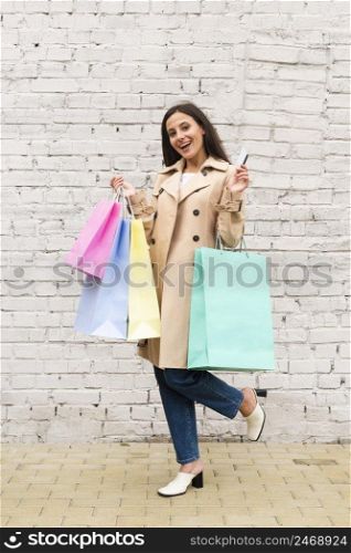 woman holding shopping bag credit card outdoors