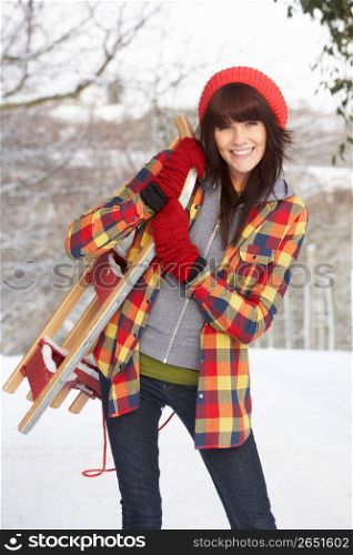 Woman Holding Sledge In Snowy Landscape