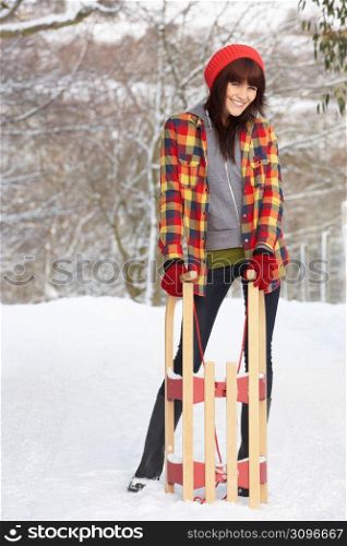 Woman Holding Sledge In Snowy Landscape