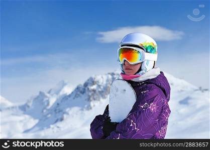 Woman holding snowboard with mountains in background. No brandnames or copyright objects.