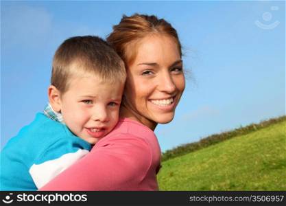 Woman holding son on her back